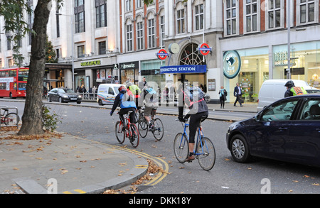 Les cyclistes négocier la circulation dans Kensington High Street Londres W8 UK Banque D'Images