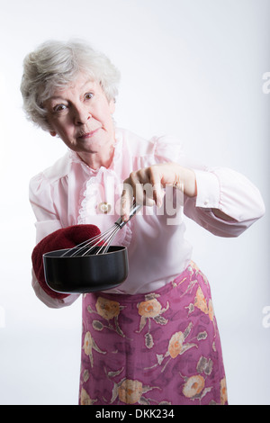 L'arrière à la femme âgée avec pot et fouet Banque D'Images
