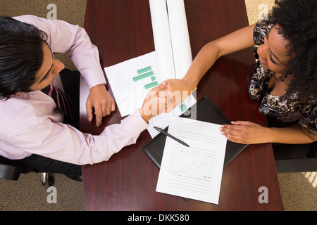 Young Indian business man shaking a woman's hand Banque D'Images