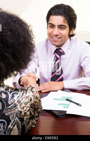 Jeune professionnel shaking a woman's hand Banque D'Images