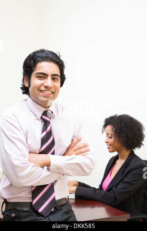 African American woman alors que patron est assis à l'avant-plan Banque D'Images
