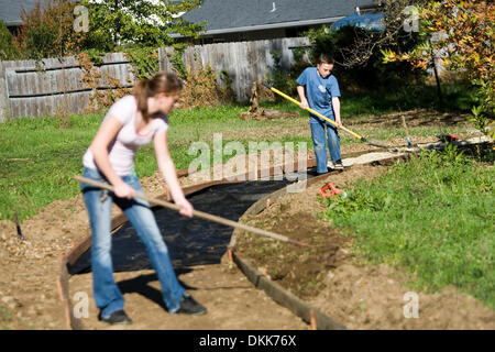 24 novembre 2009 - Redding, Californie, USA - boy-scout Westley Hughes, 13, droit et Rollins' amie Neranda Bryson, 17, à gauche, la saleté de râteau pour le nouveau sentier..Nathan Morgan/enregistrement de projecteur. (Crédit Image : © Redding Record Searchlight/ZUMApress.com) Banque D'Images