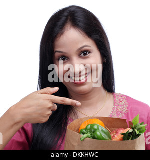 Jeune indienne holding grocery bag avec plein de fruits et légumes Banque D'Images