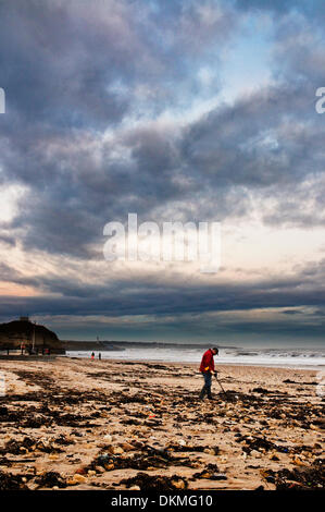 Roker, Sunderland, Royaume-Uni. 07Th Dec, 2013. Météo France : un homme avec un détecteur de métal combs la plage à Roker, Sunderland, sur la côte Est de l'Angleterre au lendemain de la plus grande tempête en 60 ans. De grosses vagues, a continué de rouler dans de la mer. Crédit : Paul Swinney/Alamy Live News Banque D'Images