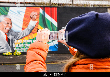 Belfast, Irlande du Nord. 7 décembre 2013 - Une femme prend une photo de la peinture murale à l'aide de Nelson Mandela un iPhone. Crédit : Stephen Barnes/Alamy Live News Banque D'Images