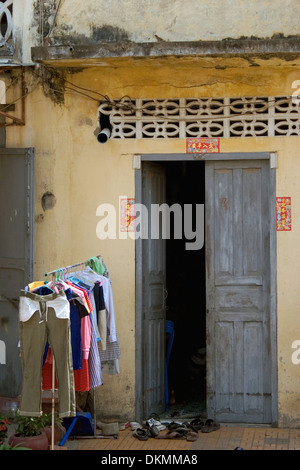 Blanchisserie colorés est accrochée à un porte manteau sur une rue de ville à une maison typique à Battambang, Cambodge. Banque D'Images