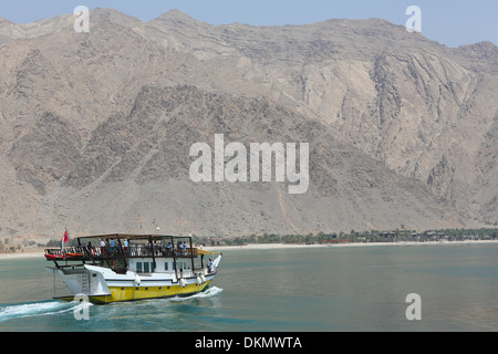 Un boutre omanais ferries les touristes le long du paysage spectaculaire de la péninsule de Musandam. Banque D'Images