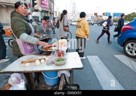 Femme vendant des saucisses sur occupation Renmin Road à Shanghai, Chine Banque D'Images