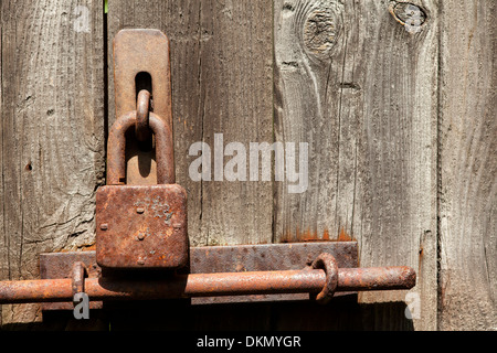 Ancien cadenas brun rouille sur des planches background Banque D'Images