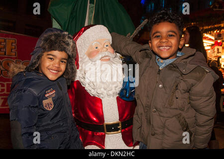 Londres le 7 décembre 2013. Deux jeunes garçons avec le Père Noël à la fête foraine à l'extrémité ouest de Leicester Square. Crédit : Paul Davey/Alamy Live News Banque D'Images