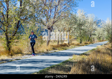 Woman jogging sur le sentier pédestre à travers petite ville de montagne de Salida, Colorado, USA Banque D'Images