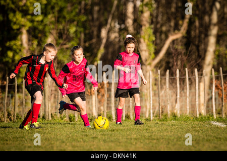 L'école primaire de garçons et de jeunes filles, jouant dans le football soccer compétitif park le samedi matin, UK Banque D'Images
