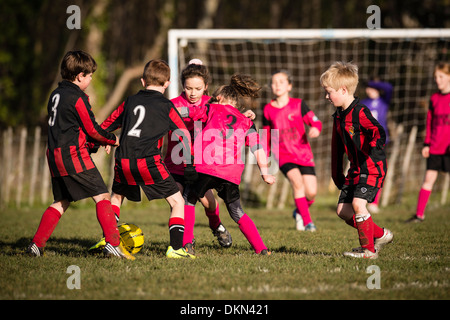 L'école primaire de garçons et de jeunes filles, jouant dans le football soccer compétitif park le samedi matin, UK Banque D'Images
