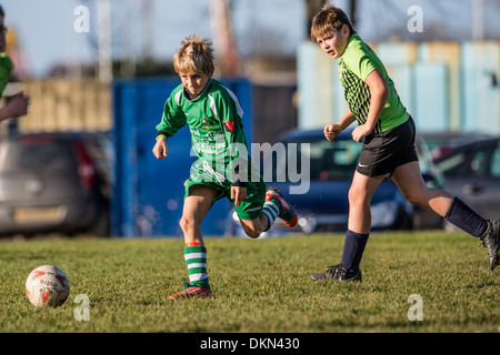 L'école primaire de jeunes garçons jouent au football soccer compétitif dans le parc le samedi matin, UK Banque D'Images