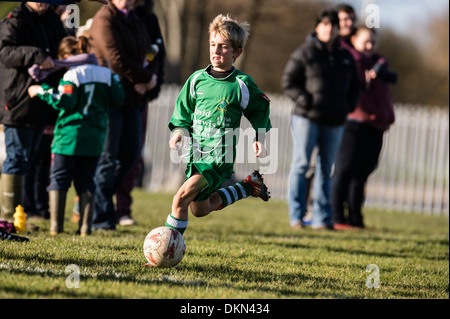 L'école primaire de jeunes garçons jouent au football soccer compétitif dans le parc le samedi matin, UK Banque D'Images