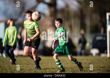 L'école primaire de jeunes garçons jouent au football soccer compétitif dans le parc le samedi matin, UK Banque D'Images