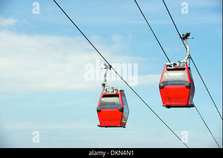 Passage cable cars de se croiser dans le ciel bleu au-dessus de Complexo do Alemao favela de Rio de Janeiro Brésil Banque D'Images