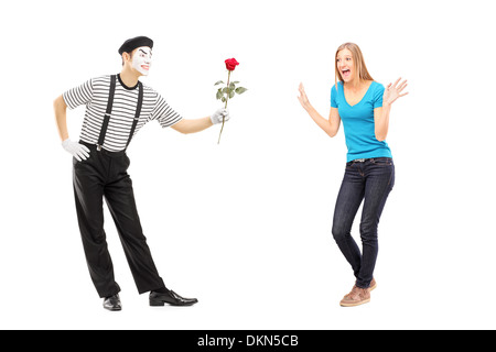 Portrait d'un artiste mime donnant une fleur rose à une femme excitée Banque D'Images