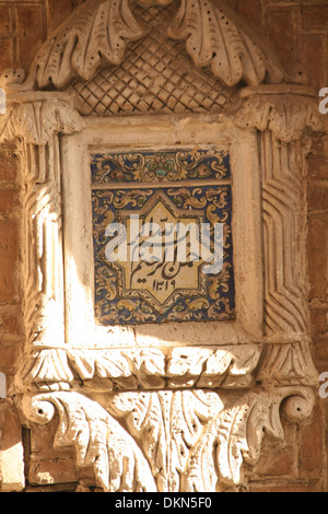 Tuile ancienne en haut d'une porte à Tabriz, Iran.Au nom de Dieu, le premier verset dans le Coran, livre saint des musulmans.Travail en plâtre. Banque D'Images