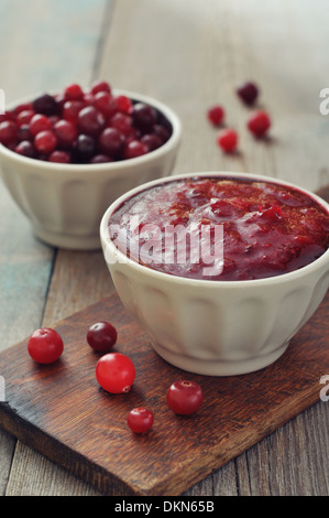 Sauce aux canneberges dans un bol en céramique avec fresh berry sur fond de bois Banque D'Images