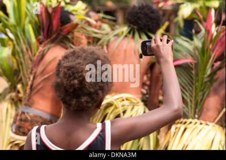 Garçon Ni-Van avec téléphone mobile Nokia tournage dancers performing dans Fest' Sawagoro une célébration de la culture traditionnelle au Vanuatu Banque D'Images