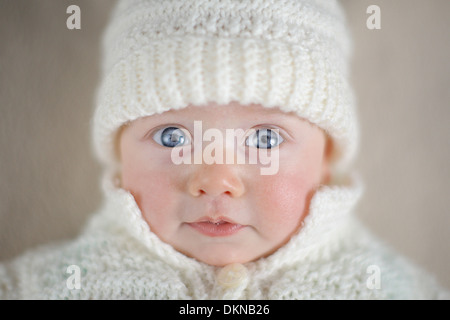 Bébé avec les yeux bleus en blanc hiver hat Banque D'Images