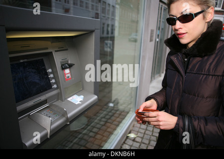 Pretty woman outdoor prenant de l'argent à un distributeur automatique de machime Banque D'Images