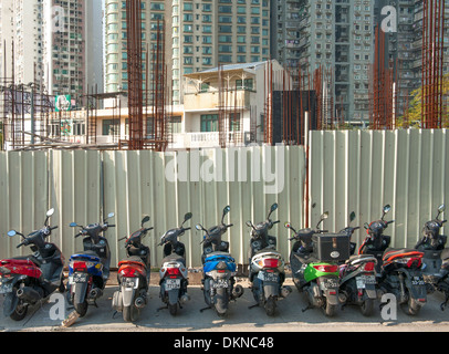 Les motos garées en face d'un site de construction, vieilles maisons remplacer par de nouveaux gratte-ciel, en plein essor à Coloane de Macao, Chine Banque D'Images