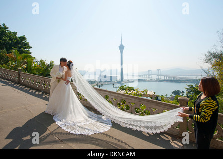 Séance photo d'un couple de jeunes mariés chinois sur Penha Hill avec vue sur la Tour de Macau, Macao, RAS de Chine Banque D'Images