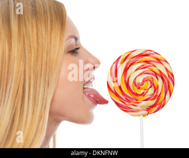 Profile portrait of teenage girl licking lollypop Banque D'Images