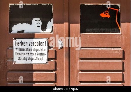 Porte de garage en bois, de l'affichage d'une zone de stationnement interdit    signe et l'image d'un fantôme et une voiture sur le crochet de remorquage d'un camion, stutt Banque D'Images