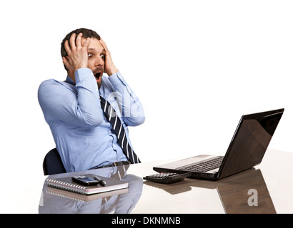 Homme d'état de panique dans l'horreur à la recherche à l'écran de l'ordinateur portable - isolé sur fond blanc Banque D'Images