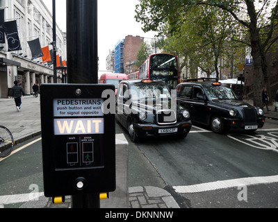 Attendre feu signe en passage pour piétons avec attente un taxi noir à Tottenham Court Road London UK KATHY DEWITT Banque D'Images