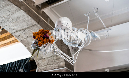 Squelette artisanale sur un trapèze volant holding bouquet de fleurs séchées en squelette musée célébrer le Jour des Morts Banque D'Images