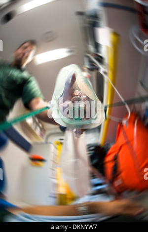 En regardant à travers les yeux du patient et de voir une ambulance man putting sur un masque à oxygène. Banque D'Images