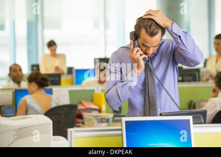 Businessman talking on telephone in office Banque D'Images