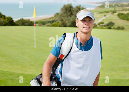 Caddy smiling on golf course Banque D'Images