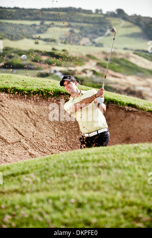 L'homme se balançant de sand trap on golf course Banque D'Images