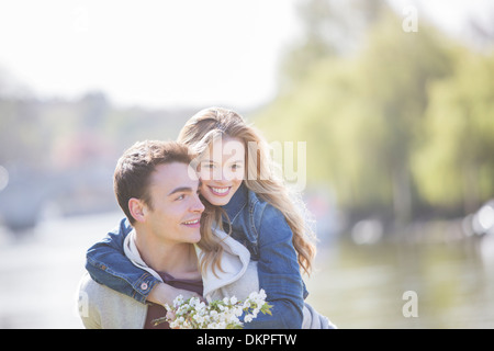 Man carrying girlfriend outdoors Banque D'Images