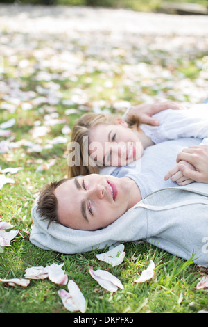 Couple laying in grass outdoors Banque D'Images