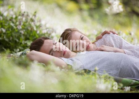 Couple relaxing together in grass Banque D'Images