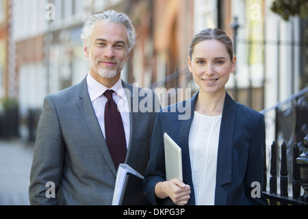 Business people smiling sur trottoir urbain Banque D'Images