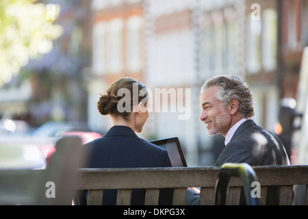 Business people talking sur banc urbain Banque D'Images