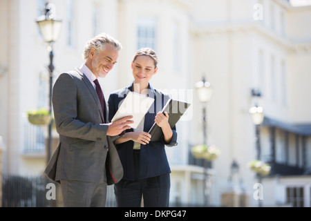 Business people talking on city street Banque D'Images