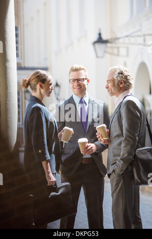 Business people talking on city street Banque D'Images