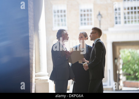 Business people talking on city street Banque D'Images