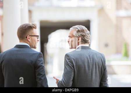 Businessmen talking on city street Banque D'Images