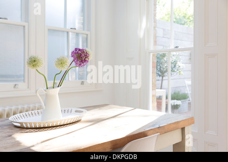 Fleurs dans un vase sur la table en bois Banque D'Images