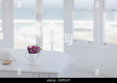 Vase de fleurs sur le bureau dans la chambre donnant sur l'océan Banque D'Images