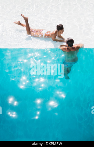 Couple relaxing in swimming pool Banque D'Images